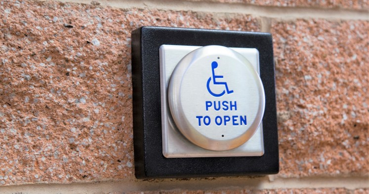 wheelchair push button on a brick wall